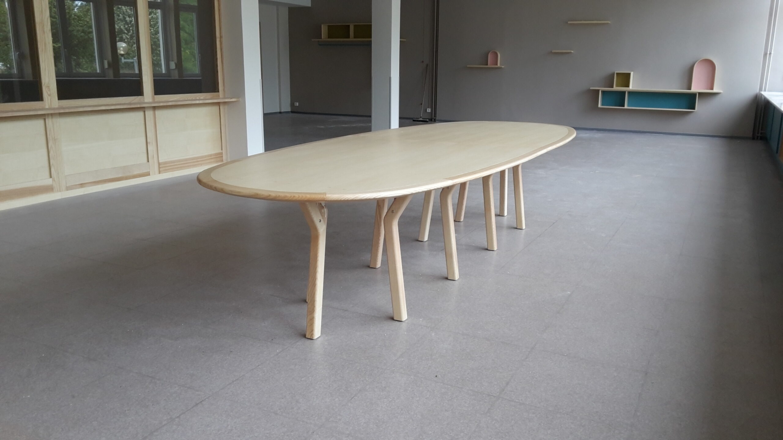 Table ovale placée au centre d’un salon aménagé par Arche du Bois, illustrant un design minimaliste et fonctionnel parfaitement intégré à l’espace.