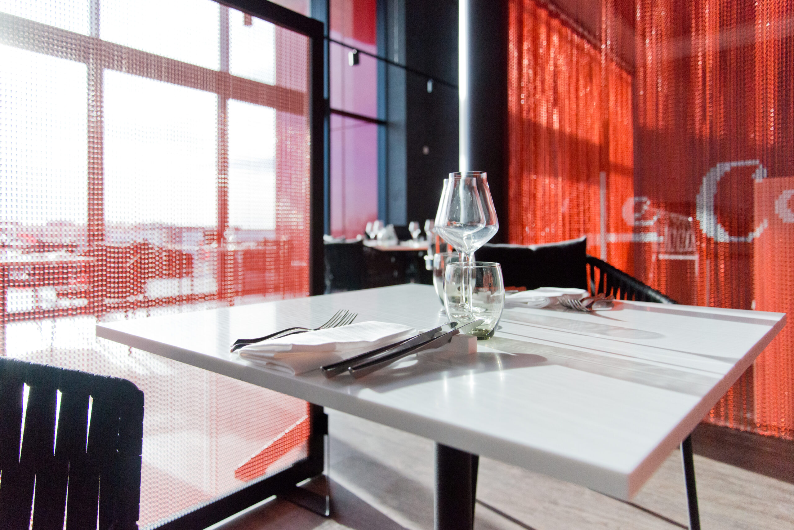 Vue rapprochée d’une table dressée avec deux chaises, comprenant verres, fourchettes et couteau