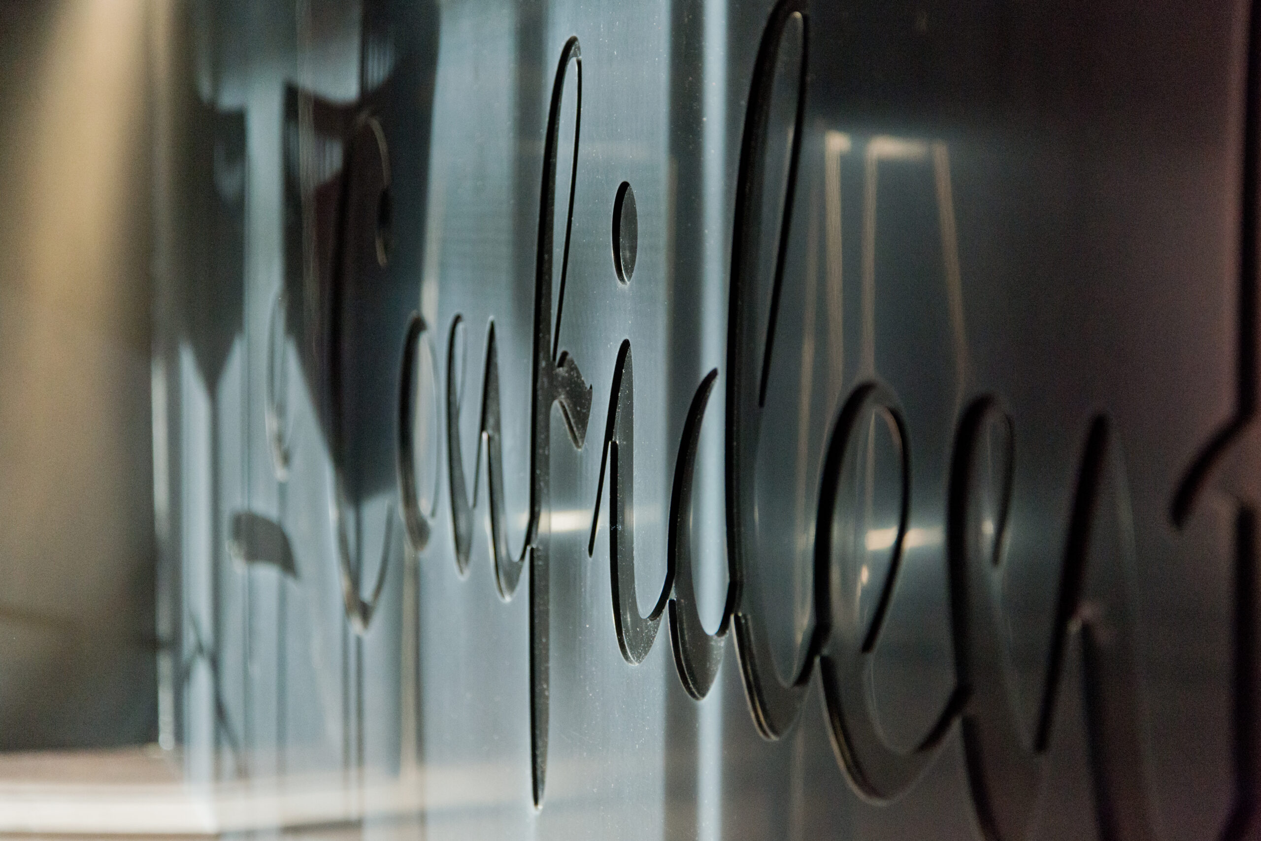 Vue rapprochée d’un comptoir de bar avec le nom de l’établissement inscrit sur la façade