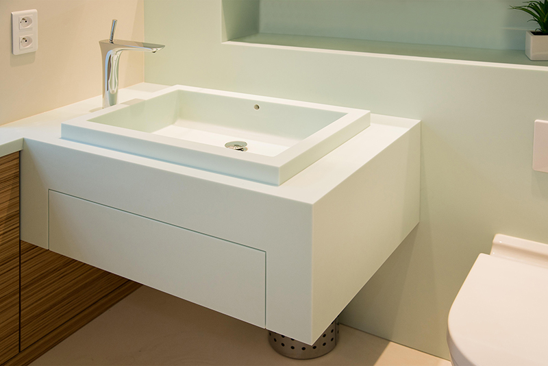 Salle de bain sur mesure par LDC Agencement – L’Arche du Bois : vasque avec robinet moderne et toilette à droite, design contemporain et agencement personnalisé.