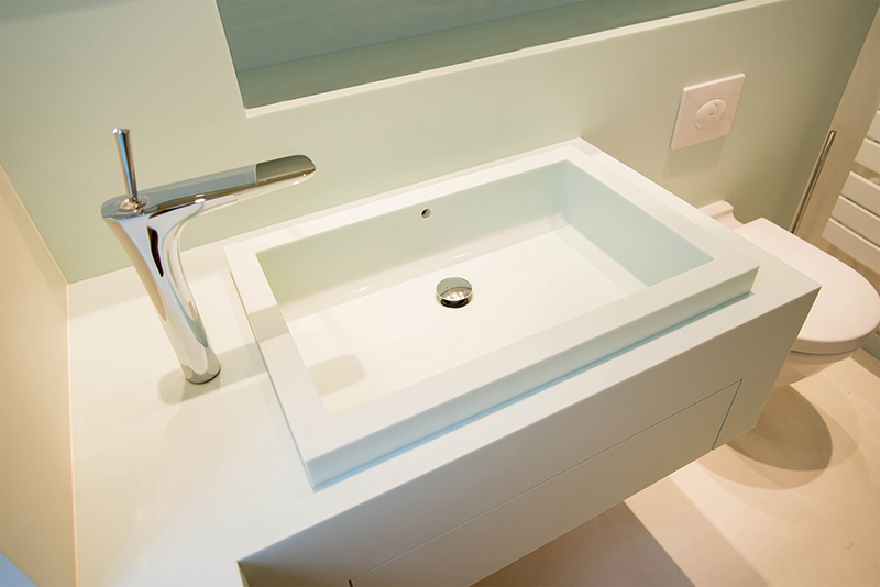 vasque avec robinet moderne et toilette à droite, design contemporain et agencement personnalisé.