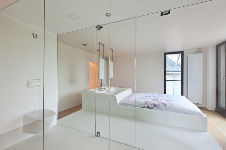 Chambre design avec un lit central surmonté d’un plan vasque intégré, illustrant un agencement innovant et sur mesure réalisé par Arche du Bois, mêlant espace nuit et zone d’eau avec élégance. L'Agencement sur Mesure​