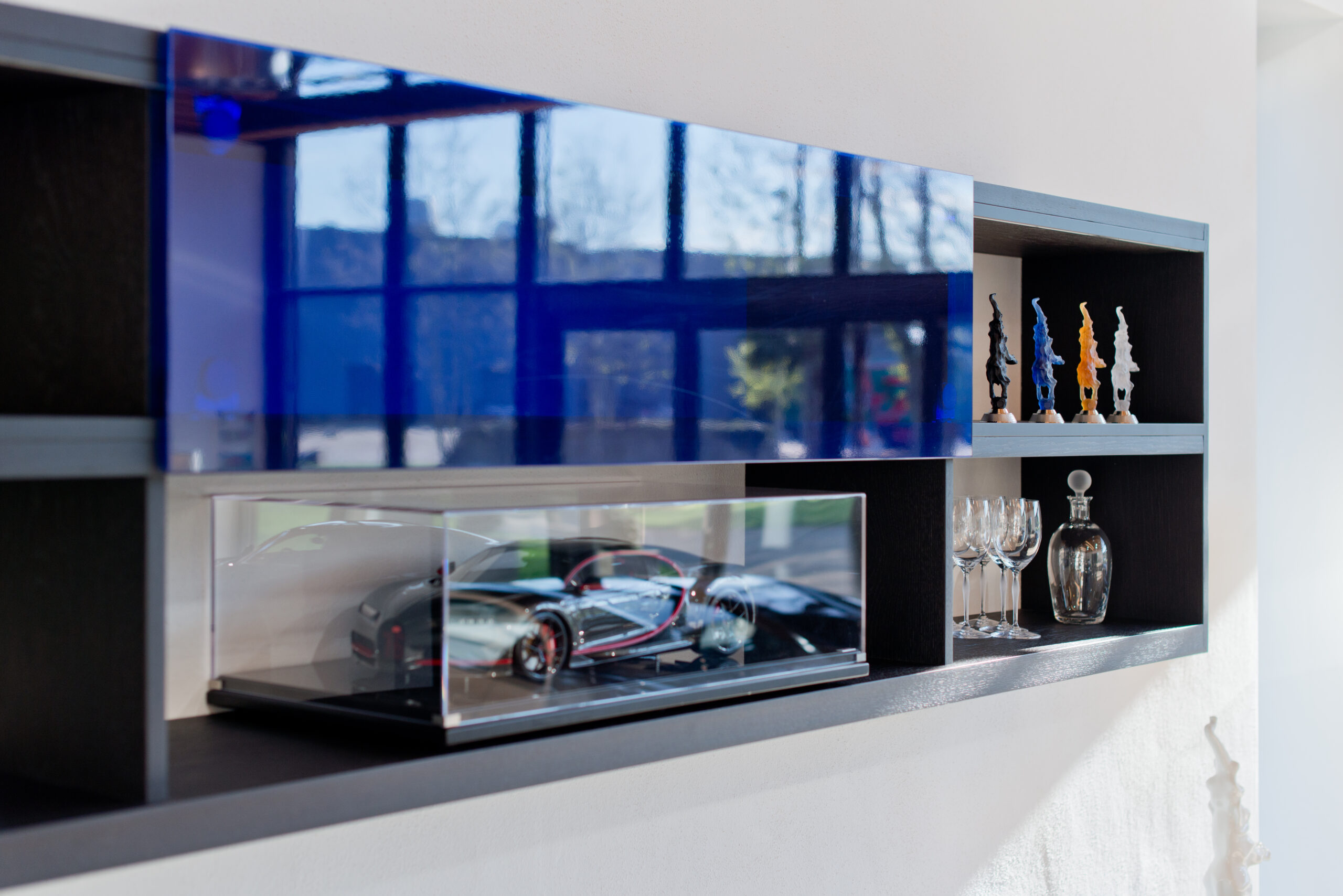 Vue rapprochée d’une étagère intégrée contenant une maquette de voiture Bugatti