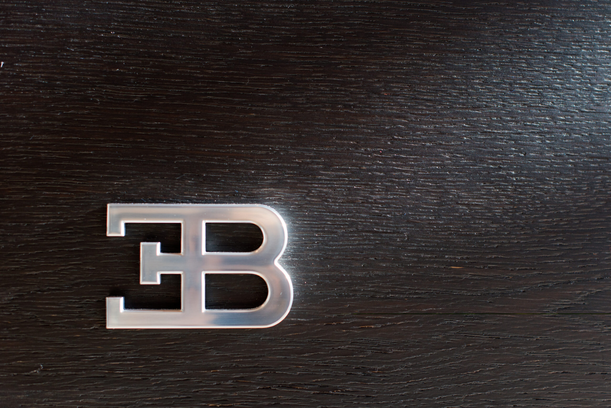 Vue rapprochée du logo Bugatti incrusté sur une surface en bois