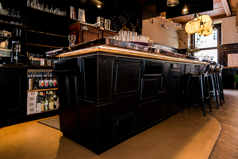 Comptoir de bar en bois teinté noir, au design épuré et contemporain — un agencement sur mesure signé Arche du Bois, alliant élégance sombre et qualité artisanale.