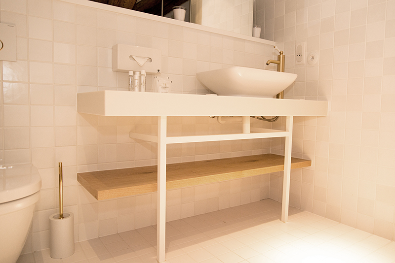 Salle de bain sur mesure par LDC Agencement – L’Arche du Bois : vasque sur pieds fins avec robinet, et toilette à gauche, design contemporain et agencement personnalisé.