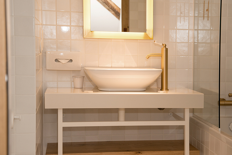 Salle de bain sur mesure par LDC Agencement – L’Arche du Bois : vasque en résine de synthèse avec robinet, miroir au-dessus, design moderne et agencement personnalisé.