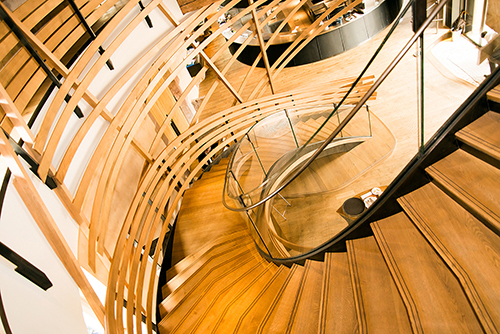 Escalier en bois descendant vers un étage inférieur, conçu avec soin pour s’intégrer harmonieusement à l’aménagement intérieur — un agencement sur mesure signé Arche du Bois, alliant fonctionnalité et esthétique naturelle.