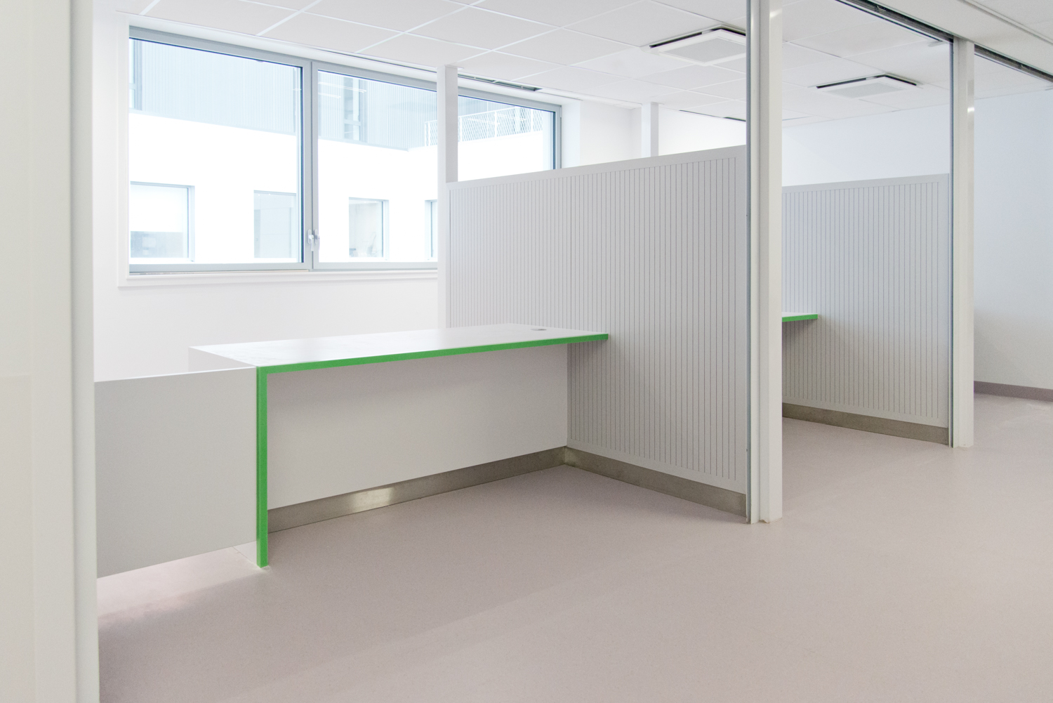 Cloisons séparées par des murets bas formant des espaces distincts, avec trois fenêtres alignées en fond de pièce — un agencement fluide et structuré réalisé par Arche du Bois, favorisant la lumière naturelle et l’intimité.