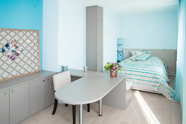 Chambre aménagée avec un bureau et sa chaise, un lit positionné à proximité, et une armoire individuelle. Un agencement fonctionnel signé Arche du Bois, alliant confort et design sur mesure. Chambre et Dressing sur Mesure Alsace