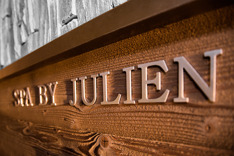 Comptoir en bois avec l’inscription "Spa by Julien" gravée ou affichée sur la façade