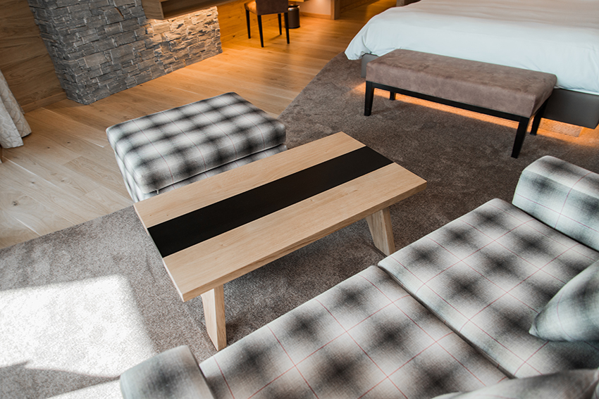 Table en bois accompagnée d’une chaise positionnée à l’arrière et d’un canapé situé à proximité