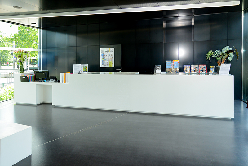 Accueil blanc au centre de l’image, encadré de deux grands vases décoratifs de chaque côté, avec une armoire noire positionnée à l’arrière-plan — un agencement élégant et structuré conçu par Arche du Bois, mettant en valeur l’harmonie entre design épuré et contrastes de matériaux