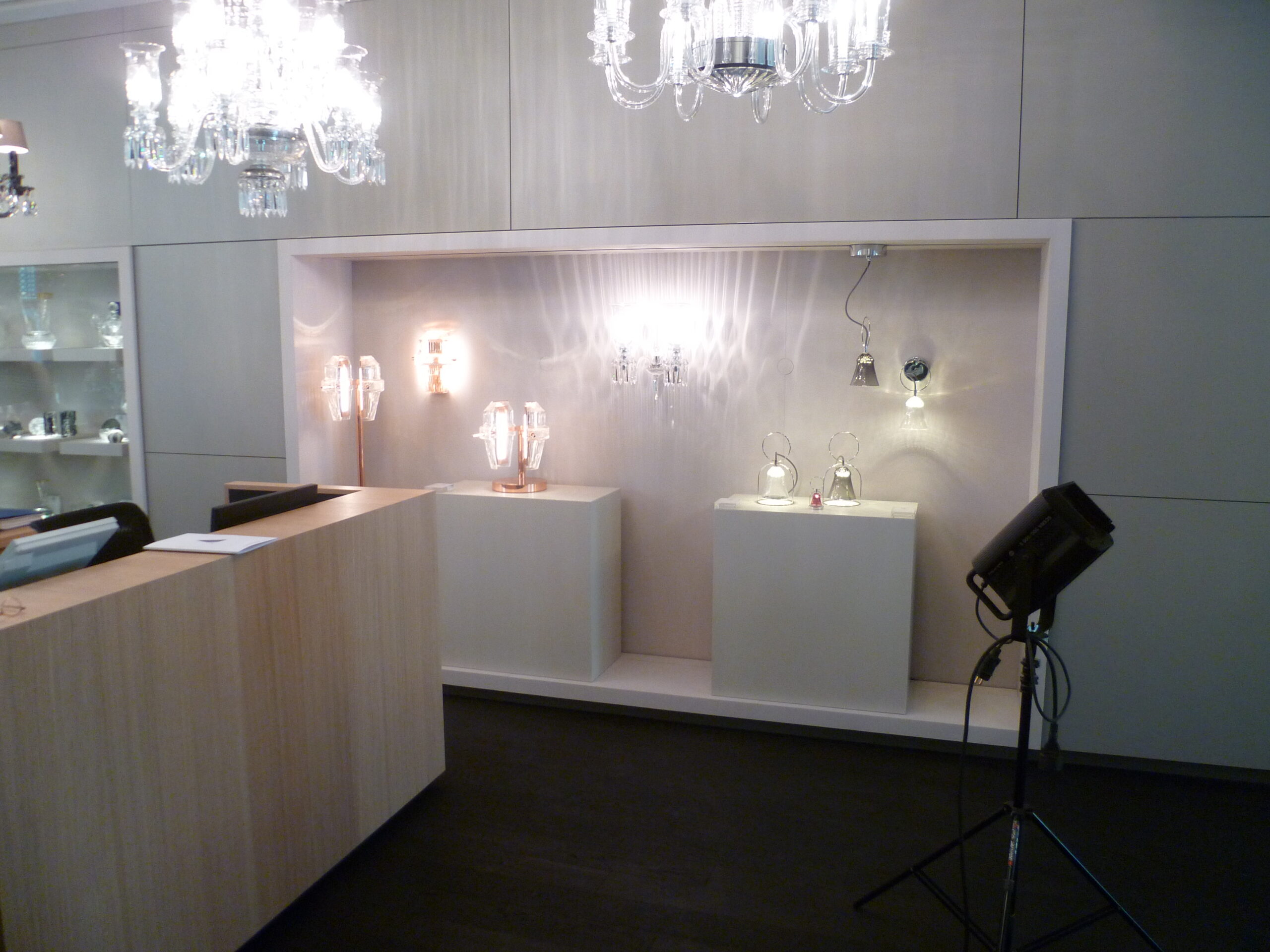 Grande vitrine d’exposition conçue par Arche du Bois pour présenter une variété de luminaires, mettant en valeur différents styles de lampes dans un agencement structuré et lumineux.