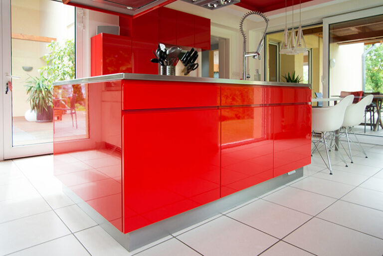 Îlot central rouge au cœur d’une cuisine moderne, servant à la fois de plan de travail et d’espace de rangement. Son design contrastant attire le regard et apporte une touche audacieuse à l’ensemble de l’aménagement