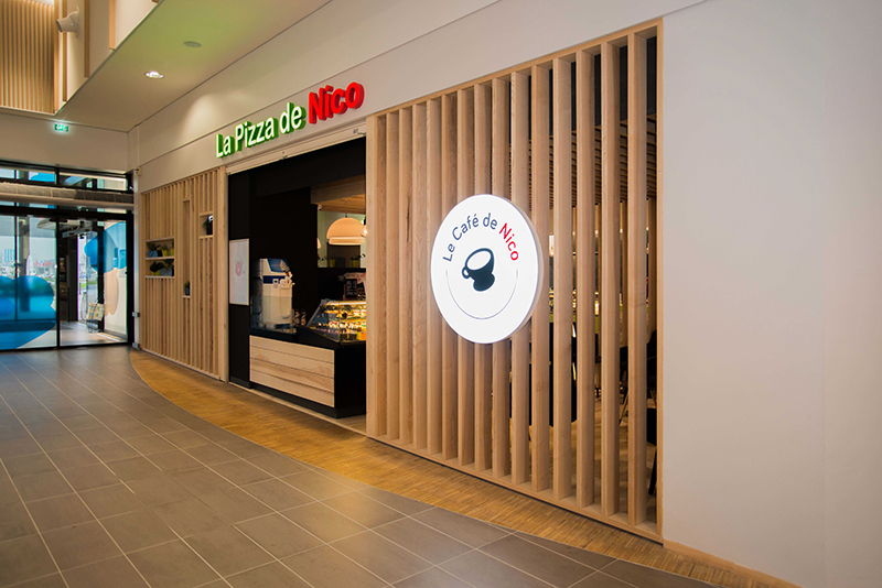 Façade extérieure de l’enseigne Pizza de Nico habillée de bois naturel, alliant modernité et authenticité