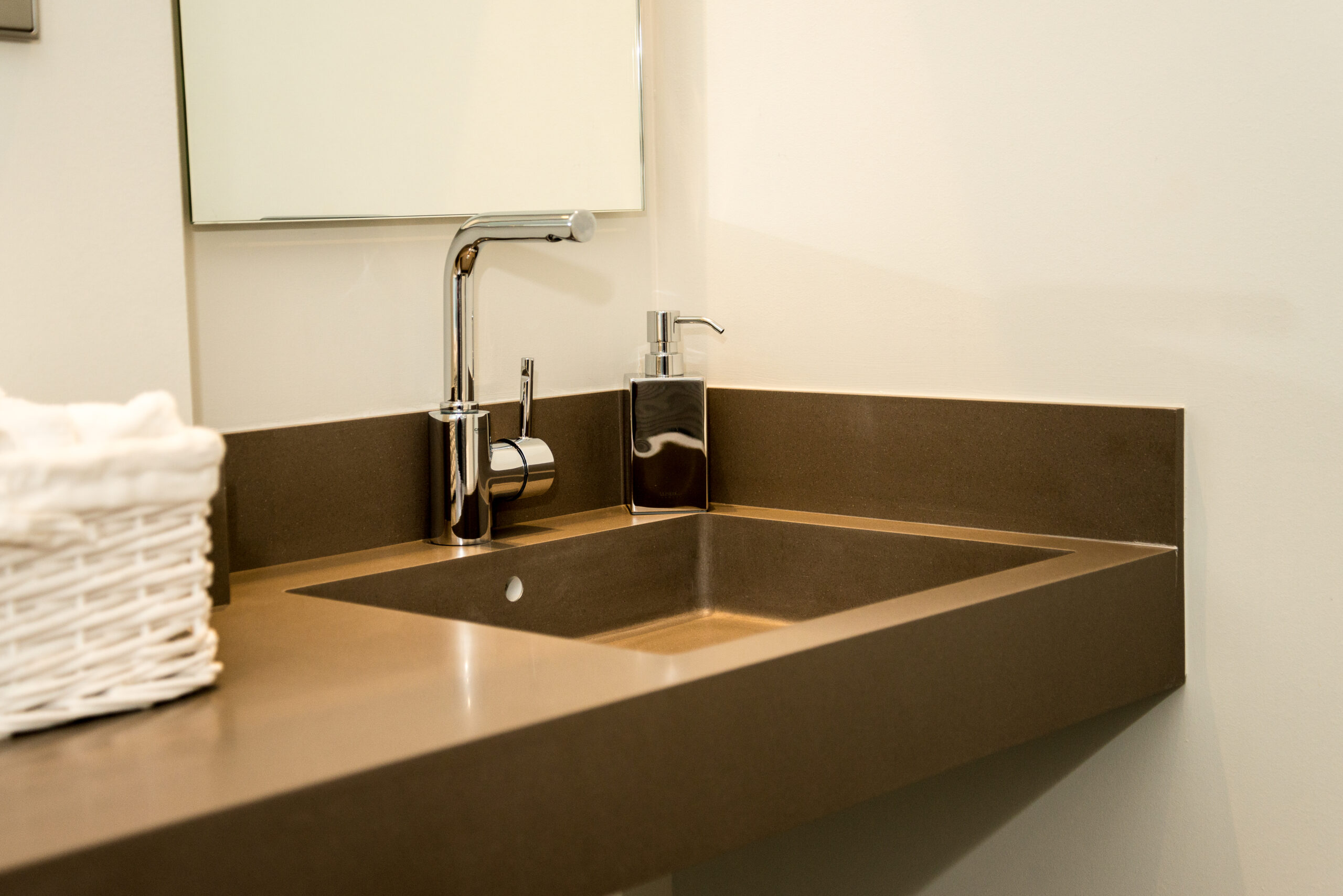 Meuble vasque brun avec un miroir mural placé juste en face