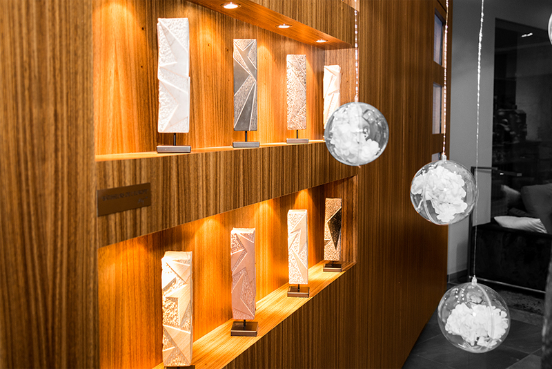 Deux étagères murales en bois avec éclairage intégré, fixées sur un mur décoré, accompagnées de trois boules décoratives suspendues — un agencement chaleureux et esthétique signé Arche du Bois, mettant en valeur la lumière et les matières naturelles.