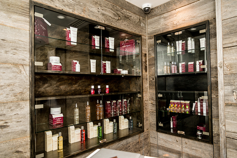 étagères d’exposition avec portes vitrées mettant en valeur différents produits à l’intérieur, et une structure extérieure en bois naturel — un agencement sur mesure signé Arche du Bois, alliant visibilité, esthétique et matériaux nobles.