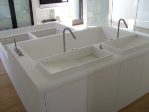 deux lavabos blancs avec robinets modernes et quatre portes de placards intégrés en dessous, mobilier fonctionnel et design contemporain.