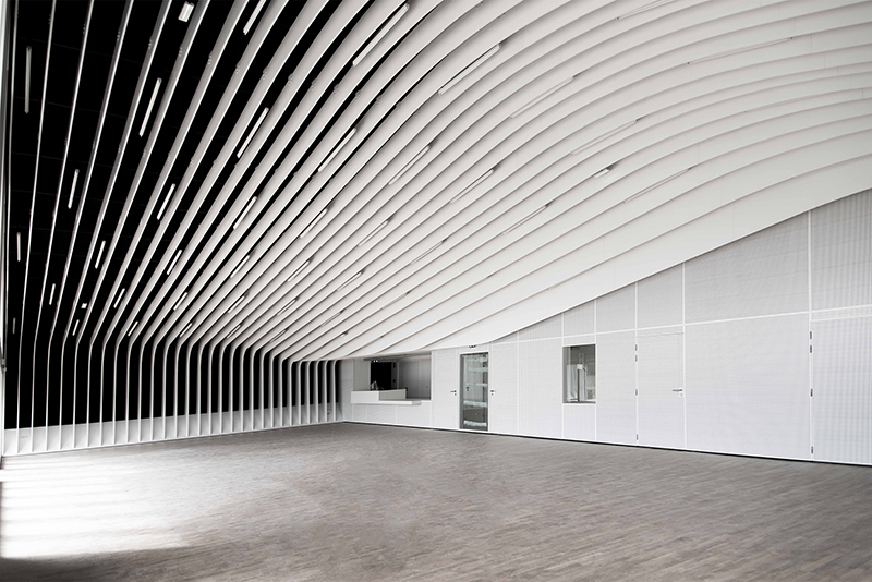 Plafond courbe avec un design rayé distinctif, complété par de une fenêtre intégrées au mur