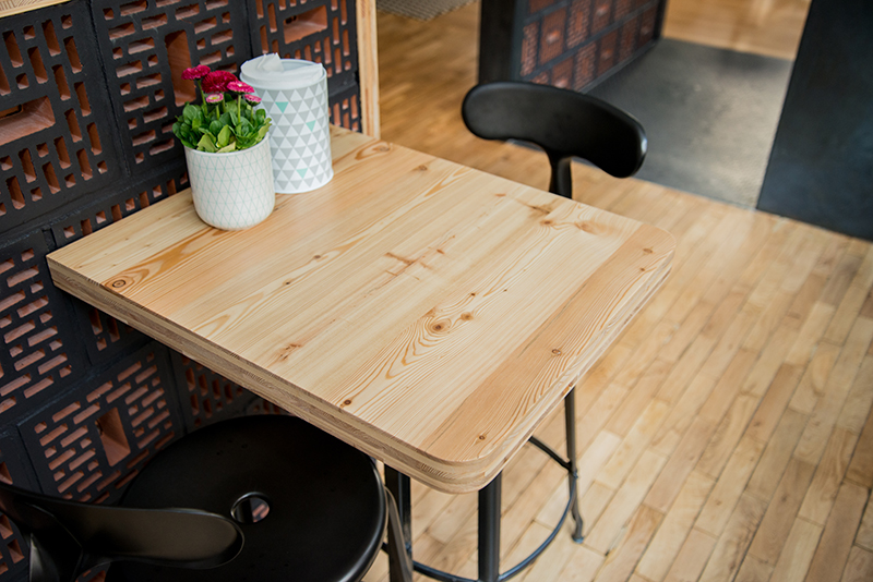 Petite table accompagnée de deux chaises, avec un vase décoratif posé au centre