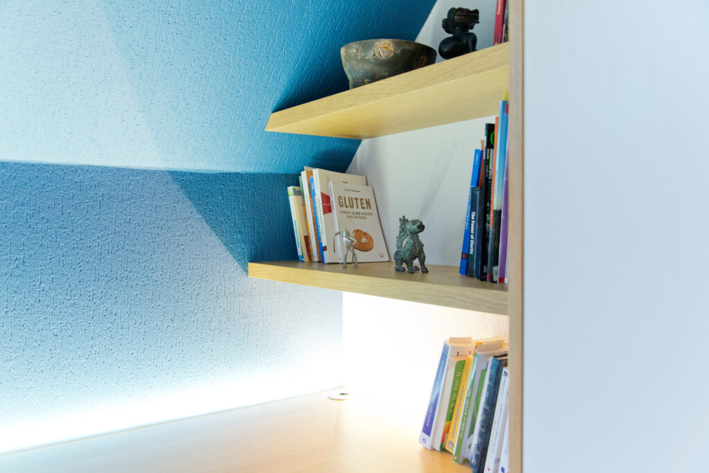 Petite étagère à livres en bois intégrée, mise en valeur par un éclairage LED discret – solution d’agencement intérieur signée Arche du Bois.
