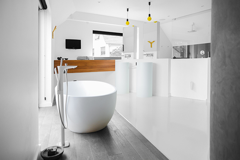 Salle de bain moderne sur mesure par LDC Agencement – L’Arche du Bois : baignoire centrale avec fenêtre en arrière-plan, design contemporain et agencement personnalisé.