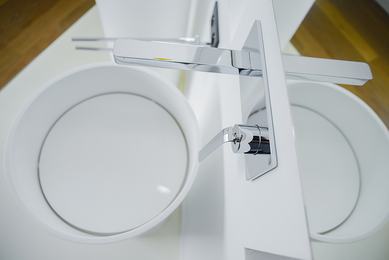 Salle de bain sur mesure par LDC Agencement – L’Arche du Bois : lavabo blanc avec robinet moderne et miroir à droite, design contemporain et agencement personnalisé.