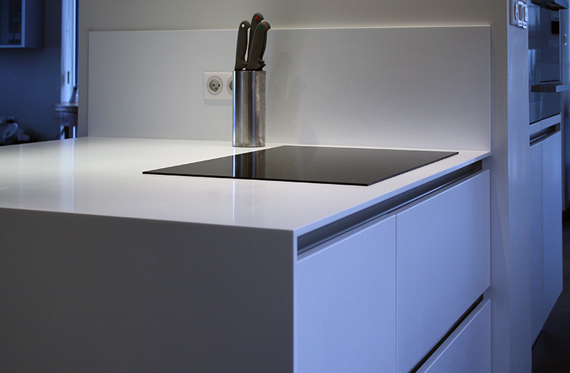 Cuisine sur mesure par LDC Agencement – L’Arche du Bois : plan de travail blanc avec plaque de cuisson noire intégrée, et placards en dessous