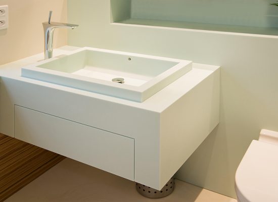 Salle de bain sur mesure par LDC Agencement – L’Arche du Bois : vasque avec robinet moderne et toilette à droite, design contemporain et agencement personnalisé.