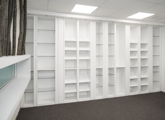 Grand meuble de rangement blanc intégrant de nombreuses étagères et niches ouvertes, conçu sur mesure pour optimiser l’espace