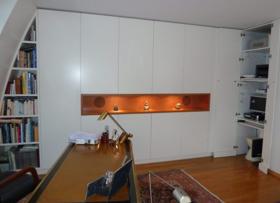 Agencement sur mesure par LDC Agencement – L’Arche du Bois : grande armoire avec étagères intégrées, bibliothèque à gauche, table devant l’armoire et rangement à droite.