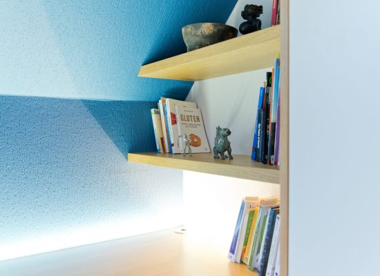 Petite étagère à livres en bois intégrée, mise en valeur par un éclairage LED discret – solution d’agencement intérieur signée Arche du Bois.